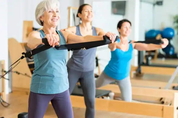 Toning Arms After 60: Empowering Womens Fitness Through Effective Weight Training 2 older woman doing weight training Waltham Abbey and resistance in the gym to tone upper arms