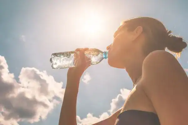 Hydration: The Secret Ingredient for a Toned Stomach and Enhanced Fitness 3 Image of woman drinking water to hydrate Waltham Abbey after run.