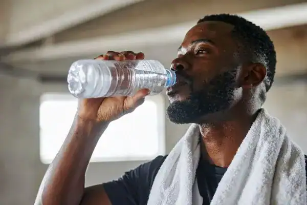 Hydration: The Secret Ingredient for a Toned Stomach and Enhanced Fitness 1 Image of man drinking water to improve hydration Waltham Abbey after work out.